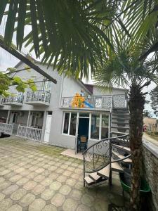 a house with a palm tree in front of it at UREKI MARI MARI in Ureki