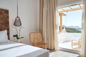 a bedroom with a bed and a hammock on a balcony at Ubud Mykonos in Agios Ioannis Mykonos