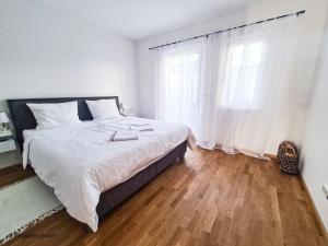 1 dormitorio blanco con 1 cama grande y 2 ventanas en Relax Suite, en Mörbisch am See