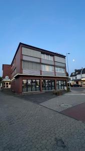 a large red brick building with windows on a street at Hotel Gifhorn INN in Gifhorn +16 photos