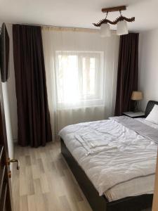 1 dormitorio con cama y ventana en Page2 Apartament, en Târgovişte