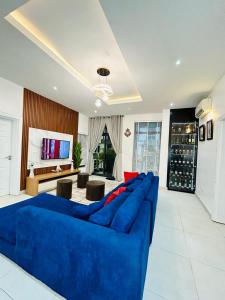 a blue couch in a living room with a tv at Luxurious1 bedroom apart in VI in Lagos
