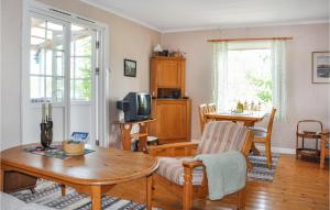 een woonkamer met een tafel en een televisie bij Cozy Home In motfors With Lake View in Åmotsfors