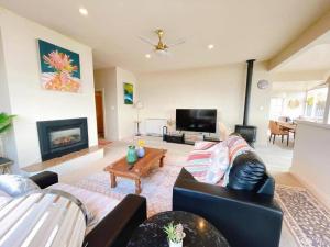sala de estar con sofá y chimenea en Incredible Waterview - 4 Bedroom Hobart Waterside Cottage, en Sandy Bay