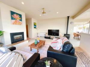 a living room with a couch and a fireplace at Incredible Waterview - 4 Bedroom Hobart Waterside Cottage in Sandy Bay
