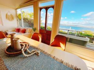 a room with a table and chairs and a large window at Incredible Waterview - 4 Bedroom Hobart Waterside Cottage in Sandy Bay