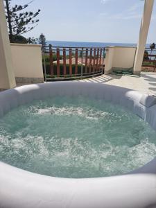 a hot tub in a patio with the ocean in the background at VILLA VEGA in Fontane Bianche