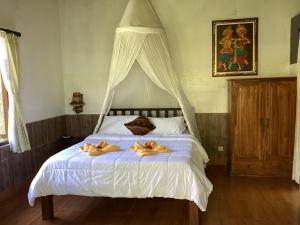een slaapkamer met een bed met twee rubberen eenden erop bij Khrisna Hs and Cottages in Sidemen