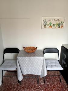 uma mesa com duas cadeiras e um cesto em cima em Comfy Studio em Lamía