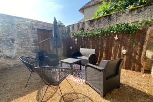 eine Terrasse mit Stühlen, einem Sonnenschirm und einem Tisch in der Unterkunft Gite du belvédère à Rocamadour in Rocamadour