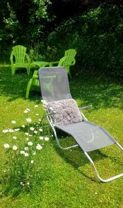 a lawn chair sitting on the grass in a yard at Zajček Apartma in Mojstrana