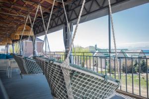 une terrasse couverte avec des balançoires suspendues au plafond dans l'établissement Silence hotel, à Cholpon-Ata