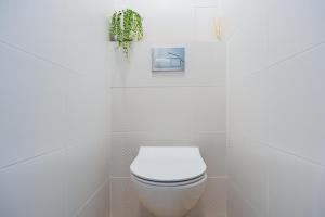 łazienka z białą toaletą i rośliną w obiekcie Apartament Nova w Olsztynie