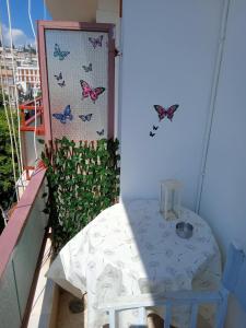 a balcony with a table and butterflies on the wall at Comfy Studio in Lamía