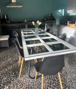 uma mesa de vidro com cadeiras pretas e um vaso de flores em Quiet Place em Machico