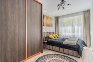 sypialnia z łóżkiem i dużą drewnianą szafą w obiekcie Apartament Nova w Olsztynie