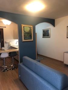 ein Wohnzimmer mit einem blauen Sofa und einem Schreibtisch in der Unterkunft casa con terrazza in Stintino