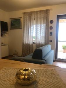 ein Wohnzimmer mit einem blauen Sofa und einem Tisch in der Unterkunft casa con terrazza in Stintino