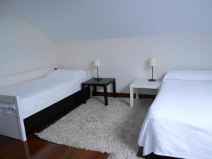 1 dormitorio con 2 camas y 2 mesas con lámparas en CASA TORRE DE GURIEZO, en El Puente