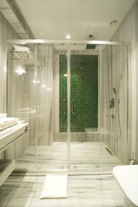 een badkamer met een douche en een glazen deur bij Tin Suites in Istanbul