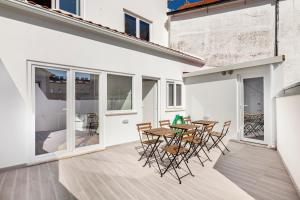 een kamer met een tafel en stoelen op een patio bij Guest House DML in Aveiro