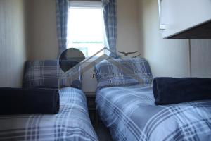 a room with two beds and a window with a window at The Rivington Lodge in Heysham