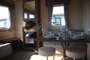 a dining room with a table and two stools and a room with a fireplace at The Rivington Lodge in Heysham +14 photos