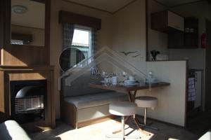 a living room with a table and a fireplace at The Rivington Lodge in Heysham