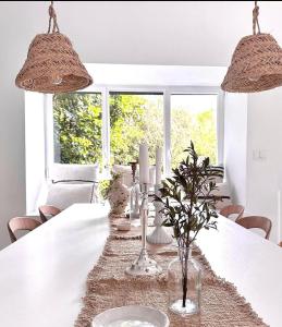 ein weißes Esszimmer mit einem weißen Tisch mit Beleuchtung in der Unterkunft Luxury Villa Heleni in Herzlia
