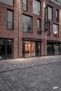 - un bâtiment en briques rouges avec des fenêtres et une rue dans l'établissement Hotel Katoen, à Goes