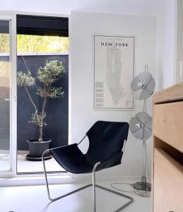 a black chair sitting in a room with a window at Luxury Villa Heleni in Herzliya