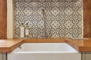 a kitchen sink with two bottles of wine next to a wall at Copper Cottage in Clare in Sudbury