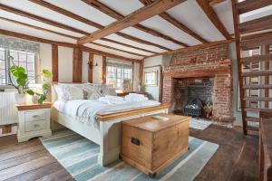 a bedroom with a bed and a brick fireplace at Copper Cottage in Clare in Sudbury