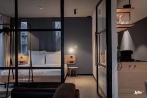 een slaapkamer met een bed en een kamer met een spiegel bij Hotel Katoen in Goes