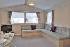 a living room with a couch and a television at Solway Holiday Park in Silloth