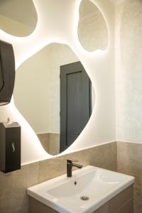uma casa de banho com um lavatório e um espelho em Silence hotel em Cholpon-Ata