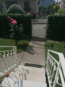 una puerta blanca frente a un patio con rosas rosas en Casa Cairoli en Mira