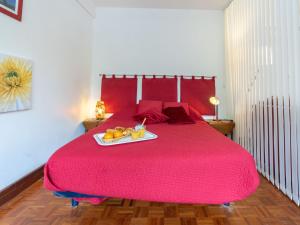 a red bed with a tray of fruit on it at Apartment Le Richelieu by Interhome in Saint-Jean-de-Luz
