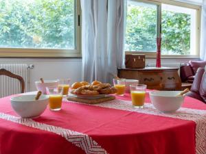 サン・ジャン・ド・リュズにあるApartment Le Richelieu by Interhomeのパンとオレンジジュースのグラスを用意したテーブル
