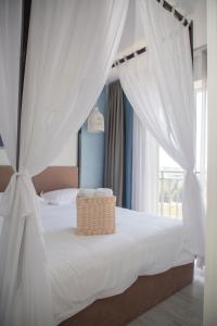 a bedroom with a white bed with a basket on it at Silence hotel in Cholpon-Ata