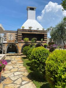 a stone pathway leading to a church with plants at Maison Apartments in Vlorë