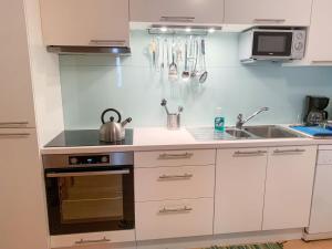 - une cuisine avec des placards blancs et une bouilloire sur le comptoir dans l'établissement Apartment App- Sollereder by Interhome, à Brixen im Thale