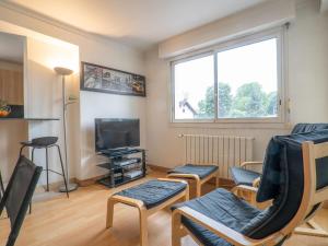 ein Wohnzimmer mit 2 Stühlen und einem TV in der Unterkunft Apartment Avenue de Biarritz by Interhome in Anglet