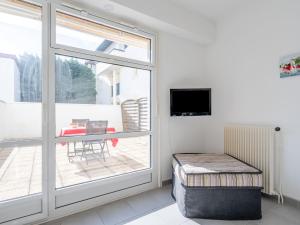 ein Wohnzimmer mit einer Glasschiebetür und einem Balkon in der Unterkunft Studio Joanis-1 by Interhome in Saint-Jean-de-Luz