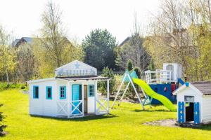 a playground with a play house and a slide at Dębki Playa Apartments in Dębki