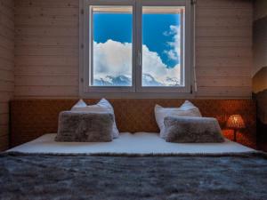 a bed with two pillows in a room with a window at Apartment Les Chouettes 23 by Interhome in Nendaz