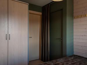 a bedroom with green walls and a closet and a door at Apartment Les Chouettes 23 by Interhome in Nendaz
