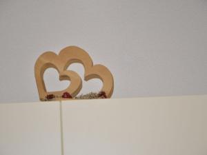 a wooden sculpture of two hearts on top of a white shelf at Holiday Home Bergblick by Interhome in Kappl