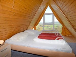 Cama en habitación de madera con ventana en Holiday Home Pfrungen by Interhome, en Pfrungen