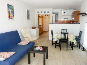 sala de estar con sofá azul y mesa en Apartment Hameau de Provence by Interhome, en Bandol